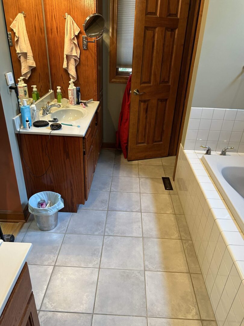 A clean bathroom with wooden vanity and tiled floor.