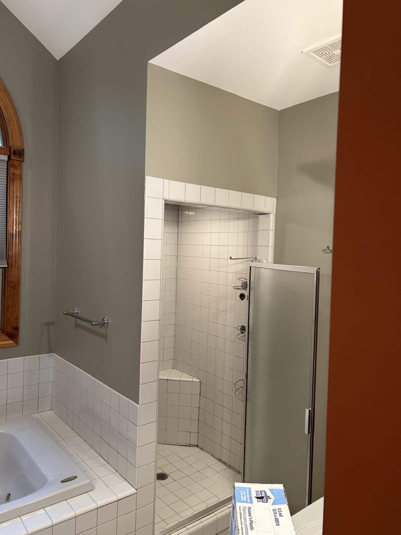 A bathroom with a built-in bathtub and a tiled walk-in shower with a glass door.