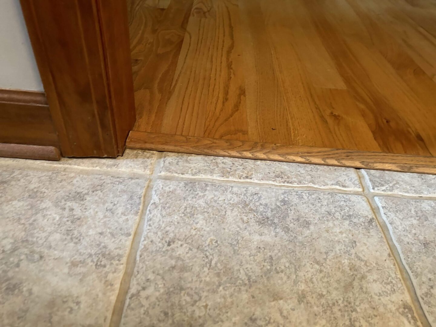 Threshold transition between tile and wood flooring in a home.