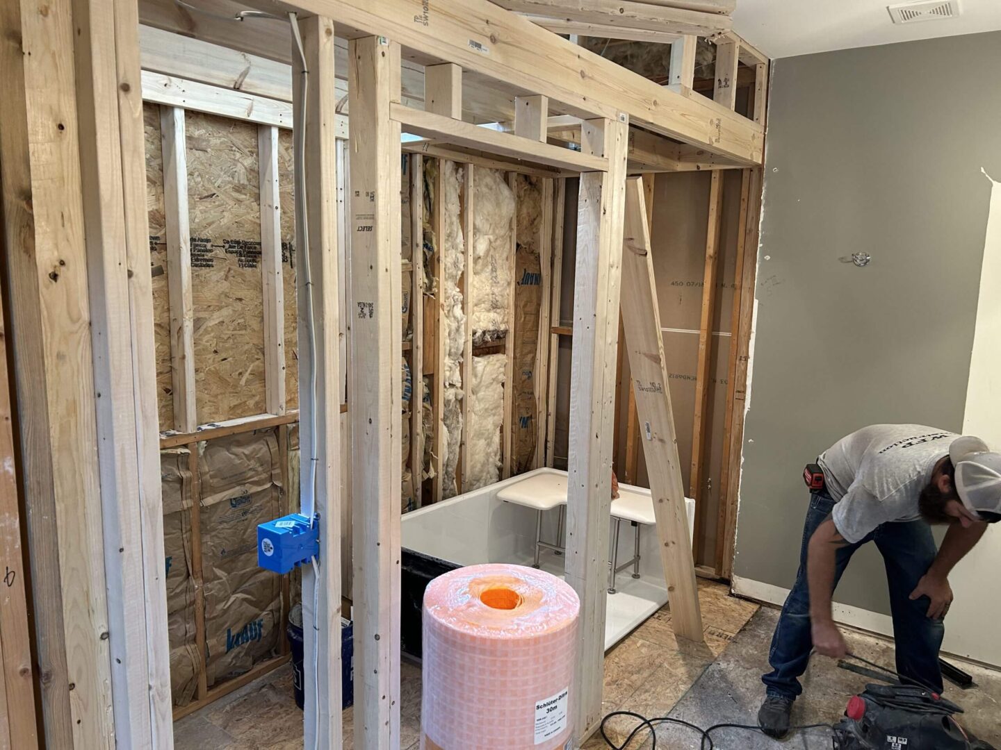 Construction of a wooden frame around a bathtub in a bathroom.