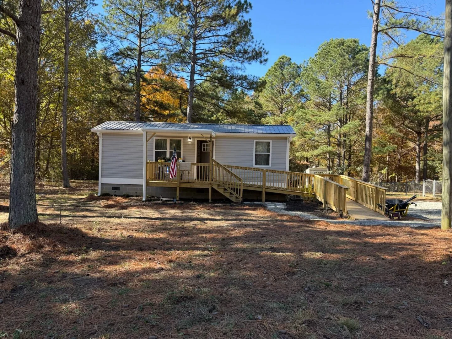 Small house with ramp in wooded area.